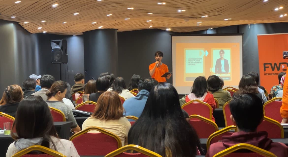 An advocate presenting to a seated audience at an Above & Beyond recruitment event