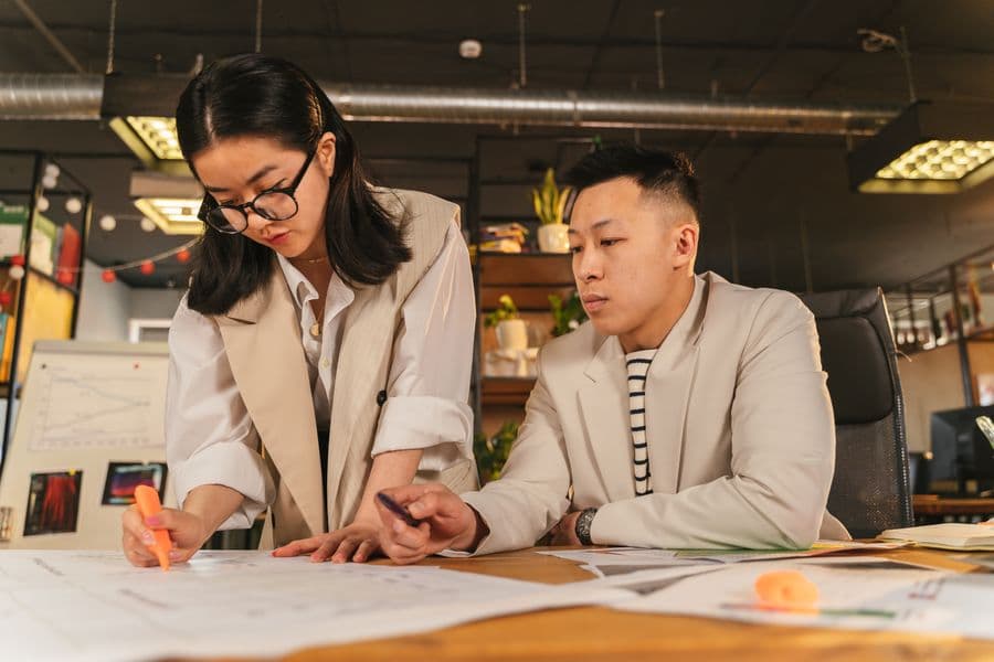 Two colleagues going through documents together at a desk