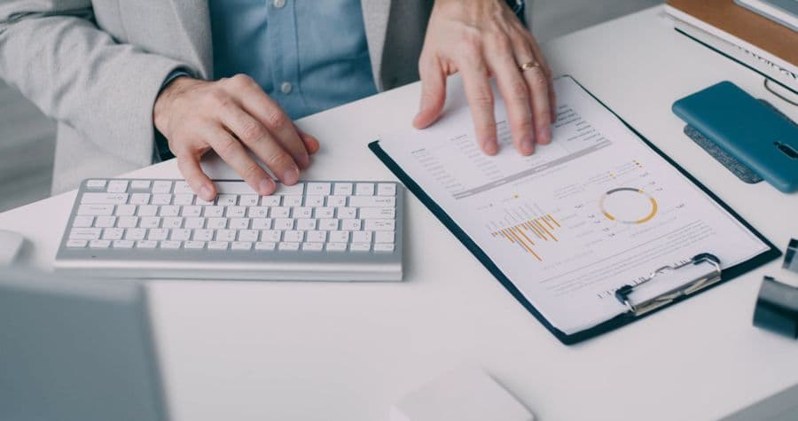 Hands reviewing a financial statement at a desk